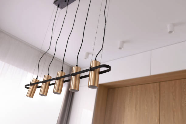 istock Decorative modern chandelier hanging on the ceiling over table in modern white room. Pendant Sconce Lighting Lamp. Modern interior design 1783644098