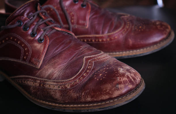 Close up worn old red brown leather scratches and scuffs on men oxford shoes stock photo