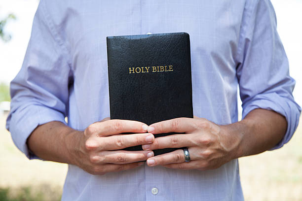 Man Holding Black Bible stock photo