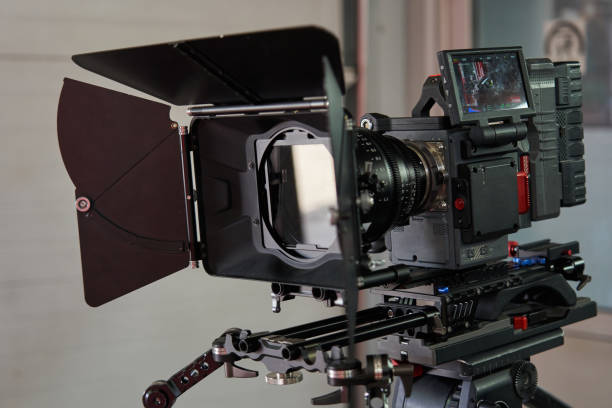 istock professional movie camera in full equipment. camera cube, professional lens, compendium, rechargeable battery, handles and camera trolley 1783663152
