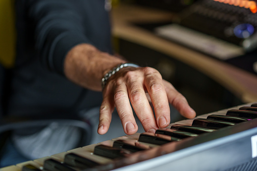 Music production in studio: Hands on piano keys - Keyboardist close-up shot