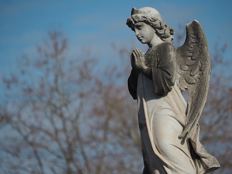 Statue of an angel with wings praying