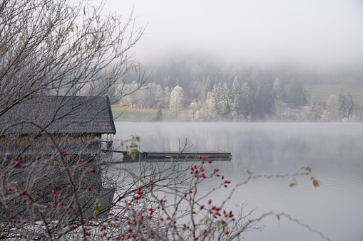 A lake with boat shed in winter