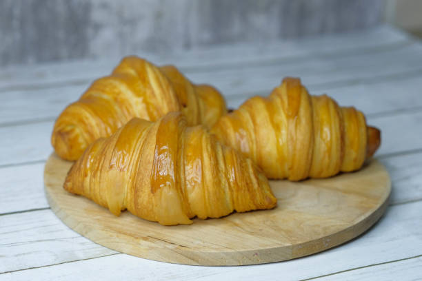 Some fresh croissants on a wooden surface