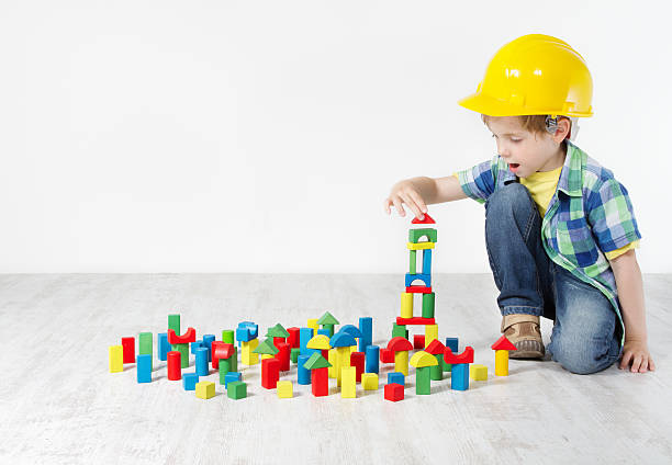 kinder zimmer, kind schutzhelm spielen spielzeug bausteine - construction toy stock-fotos und bilder