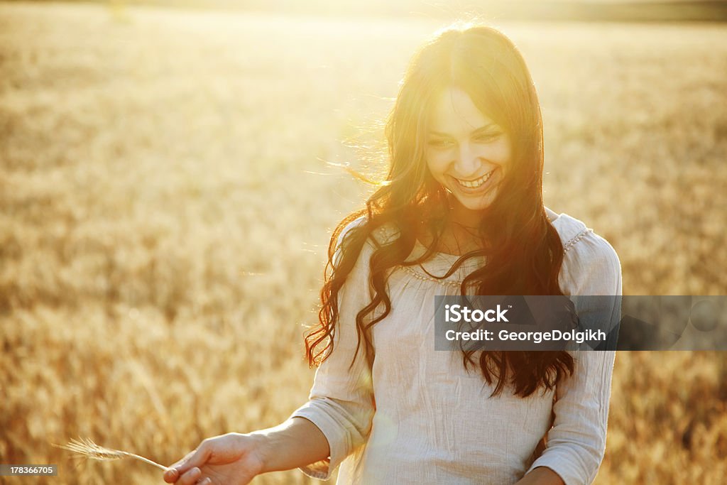 Beautiful lady in wheat field Beautiful brunette lady in wheat field at sunset Agricultural Field Stock Photo