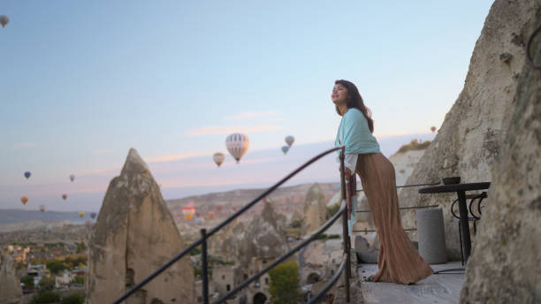 portret młodej turystki oglądającej balony na ogrzane powietrze z balkonu w kapadocji podczas podróży - hot air balloon landscape sunrise mountain zdjęcia i obrazy z banku zdjęć