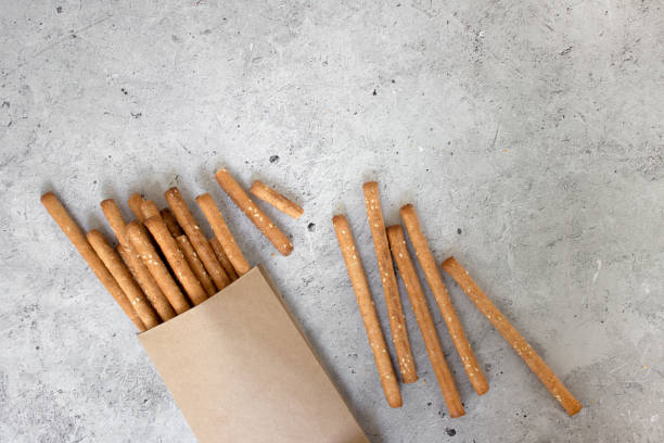 istock Bread sticks, with sesame seeds and whole grain flour on grey background. Top view, copy space. 1783670359