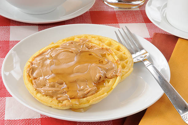 Two golden waffles with peanut butter and honey close up