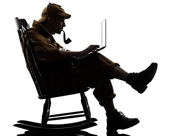 sherlock holmes with computer laptop silhouette sitting in rocking chair in studio on white background