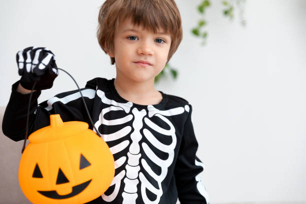 istock a child in a halloween costume sits with pumpkin 1783673765