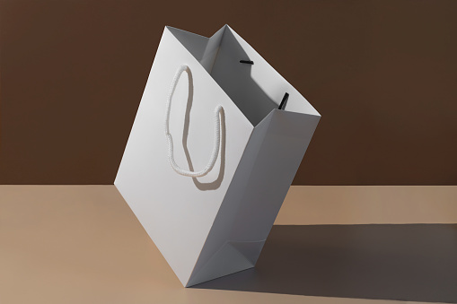 Paper shopping bag on brown background.