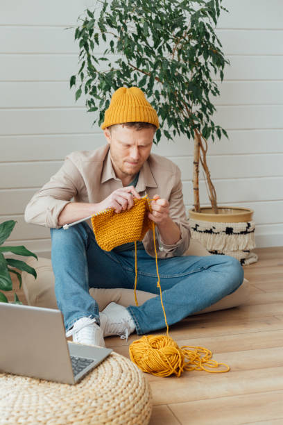 istock Middle aged man knitting at home. Knitting project in progress. Man learning a new hobby 1783678510