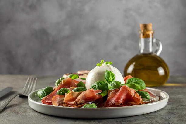istock Buffalo burrata cheese served with fresh tomatoes, prosciutto, and basil leaves. 1783682594