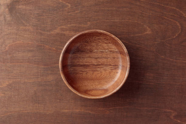 istock An empty wooden round bowl on the brown wooden table with copy space 1783683149
