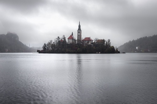 A scenic lakeside landscape featuring a small island in the middle of Lake Bled in Slovenia.