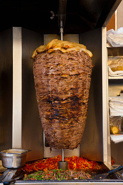 A large piece of shawerma lamb meat cooks in a machine often found in the restaurants of the Middle East.