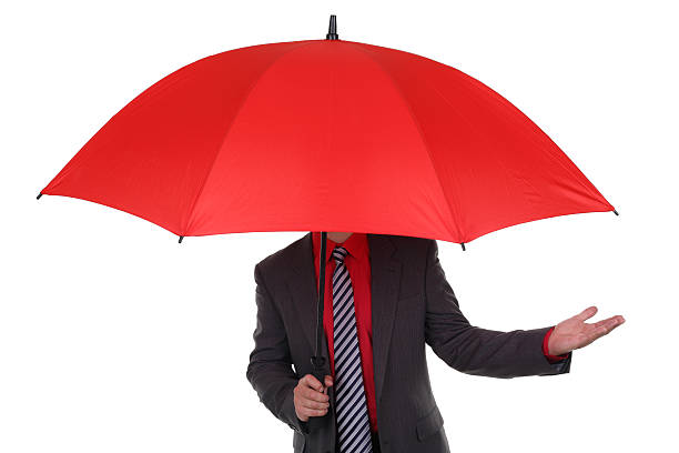 homme d'affaires tenant un parapluie rouge - human hand sheltering men making photos et images de collection