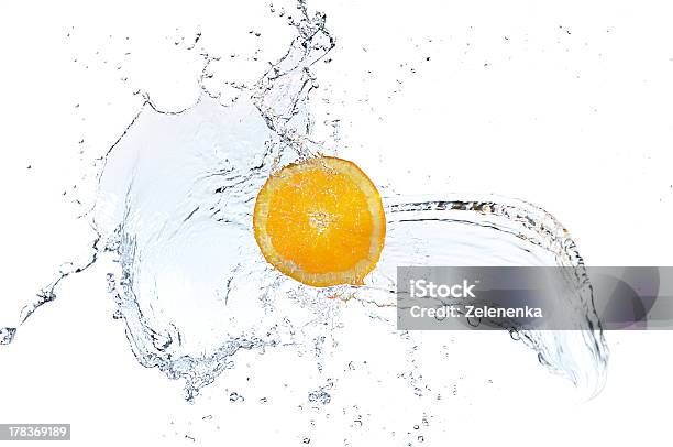 Rodaja De Naranja Caer Y Jugando En El Agua Clara Foto de stock y más banco de imágenes de Alimento - Alimento, Amarillo - Color, Bebida