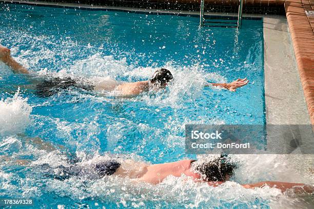 Two Male Swimmers Racing To Touch The Wall In A Pool Stock Photo - Download Image Now