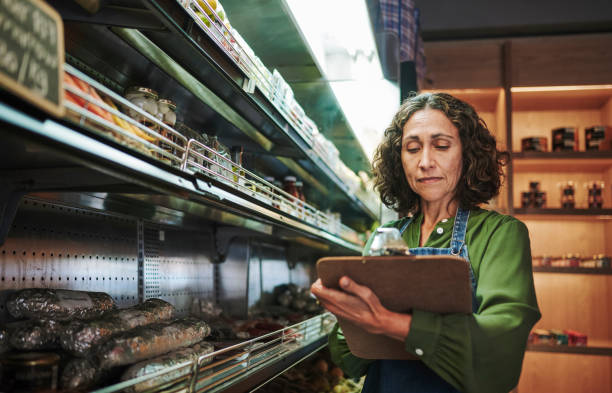 istock Mature deli owner using a clipboard to check stock in her store 1783702802