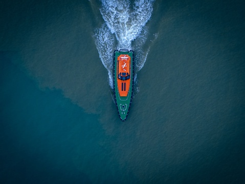 An aerial view of a pilot boat voyaging across a majestic blue body of water
