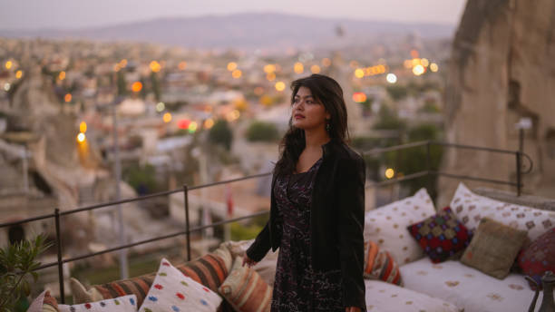 ritratto di giovane turista che guarda i balloni ad aria calda dal balcone in cappadocia durante il suo viaggio - traditional festival adventure air air vehicle foto e immagini stock