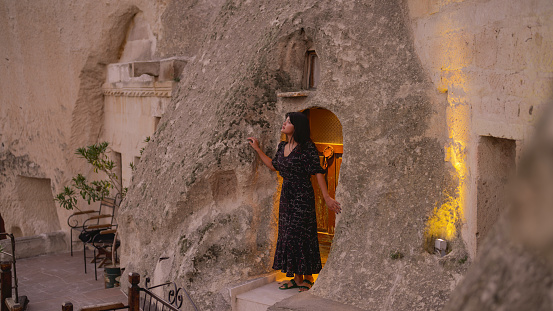 Portrait of young female tourist watching hot air ballons from balcony in Cappadocia during her travel.