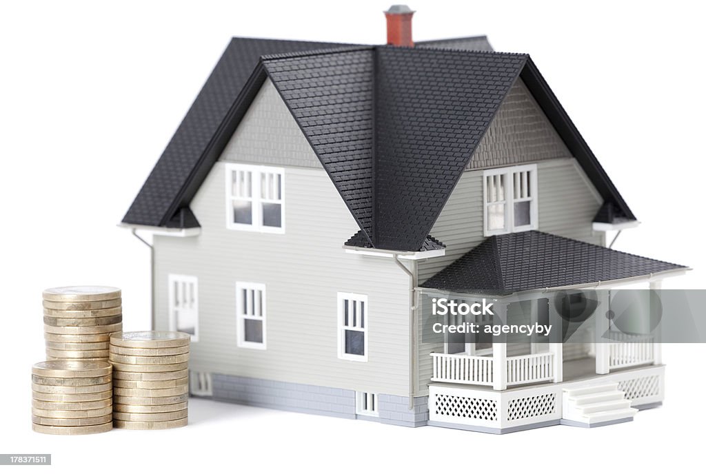 Coins in front of home architectural model "Real estate concept - stacks of coins in front of home architectural model, isolated" Architectural Model Stock Photo