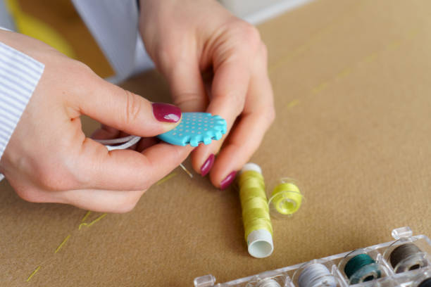 istock Tailor with needle in hands cutting thread. Woman seamstress at workplace. Closeup needlework 1783724887