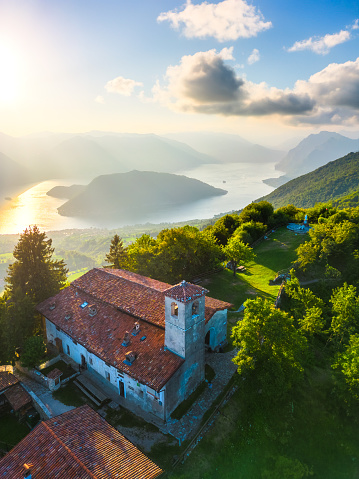 Vertical aerial view of lake Lago d'Iseo and Montisola from Santa Maria del Giogo during summer sunset. Sulzano, Iseo, Lombady, Italy