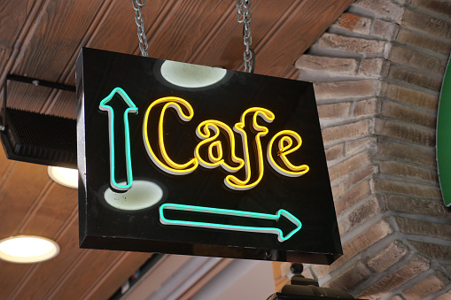 Glowing neon sign with words cafe