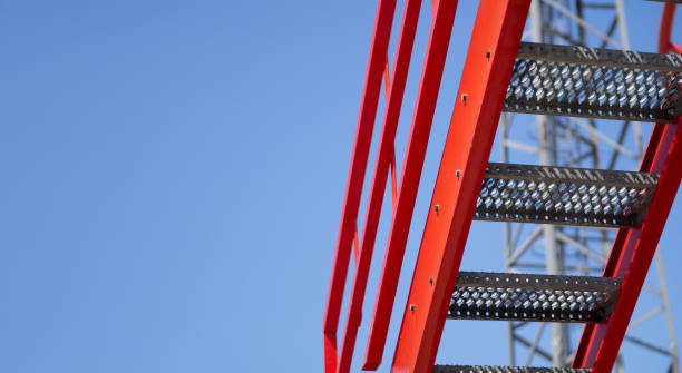 istock Red metal stair fire escape or emergency exit on with Blue Sky background. Building design requirements for fire safety at work 1783729184