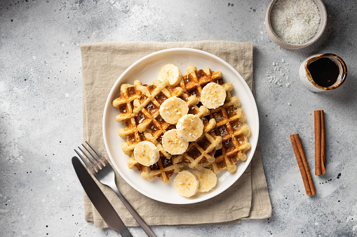 Vegan oatmeal waffles with bananas, cinnamon, coconut and date syrup