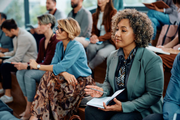 istock Mature entrepreneur writing in her notebook while attending a business seminar at conference hall. 1783743736