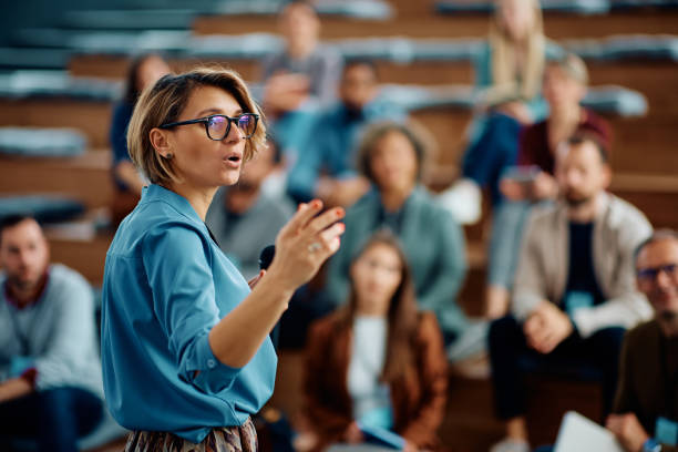 female speaker giving a presentation during business seminar at convention center. - ceo corporate business indoors lifestyles imagens e fotografias de stock