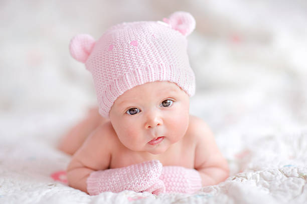 neonato bambino ragazza in rosa cappello lavorato a maglia con orsetto - baby sleeping bedding teddy bear foto e immagini stock