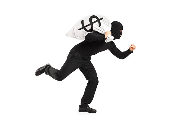 istock A thief dressed in all black runs away with a money bag 178374759