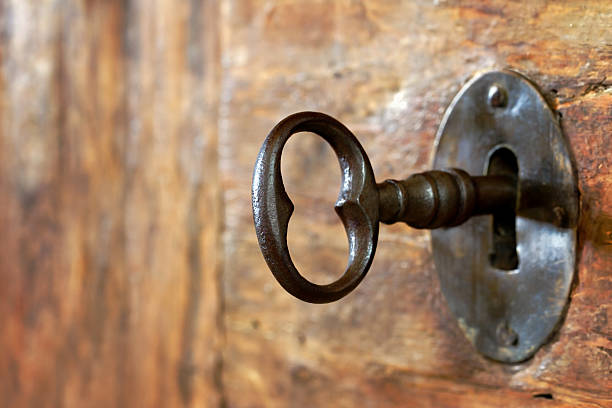 primo piano di un vecchio buco della serratura con chiave - keyhole lock door antique foto e immagini stock