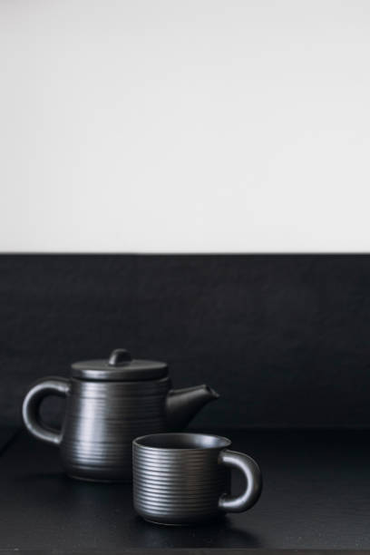 istock Closeup of black ceramic teapot and cup on background with copy space 1783751527