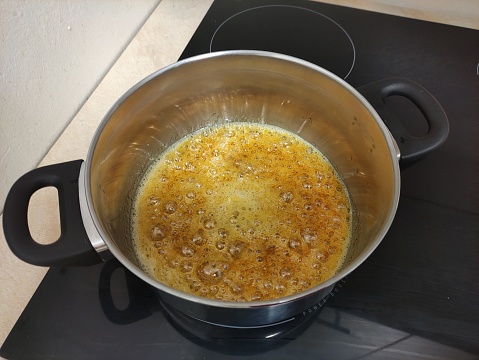 Sugar syrup boils in the saucepan. Preparation of paste for sugaring.