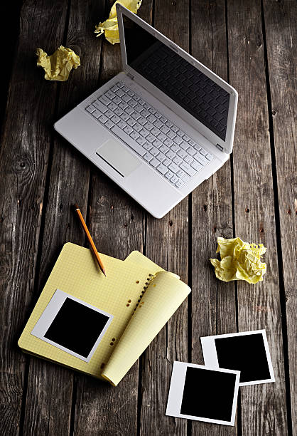 istock Laptop, instant photos and crumpled paper on table. 178377134