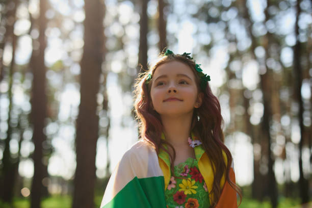 menina ruiva adorável coberta com bandeira da irlanda no festival do dia de são patrício ao ar livre - republic of ireland flag human face irish culture - fotografias e filmes do acervo