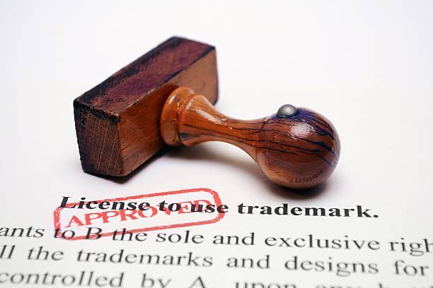 Trademark license Close up of wooden stamp on Trademark license form publisher photos stock pictures, royalty-free photos & images