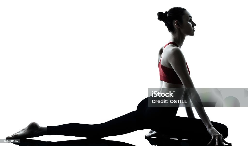 Woman in red tank top doing dynamic stretching one caucasian woman exercising yoga in silhouette studio    on white background Adult Stock Photo