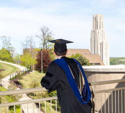 Doctoral graduate looking toward Cathedral of Learning at University of Pittsburgh