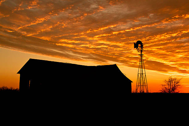 Sunset with farm house and windmill stock photo