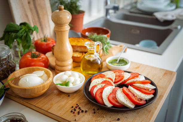 Caprese - mozzarella, tomato, green basil on a white plate with gravy on a cloth. High quality photo
