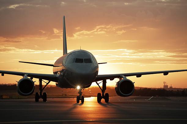 夕暮れの空港 - landing sunset airplane flying ストックフォトと画像