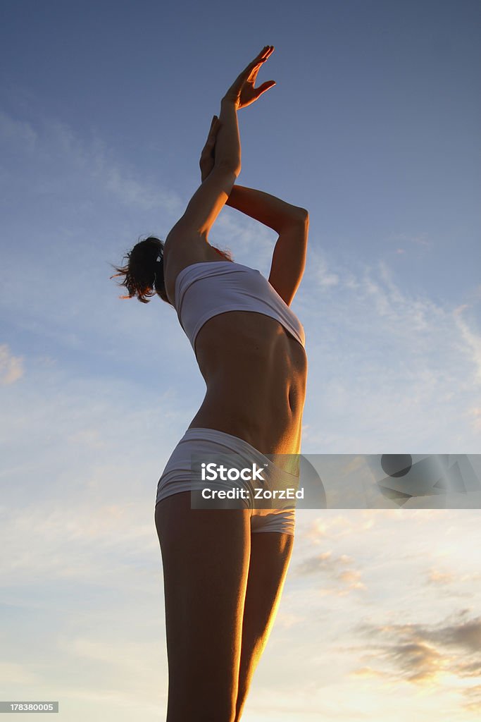 Graciosa jovem mulher em exercício atender a luz do nascer do sol - Foto de stock de Abdome royalty-free